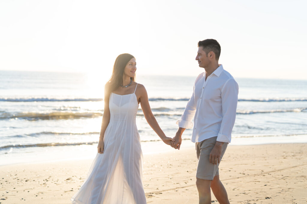 Pareja compartiendo un abrazo tierno en la playa La Patacona, Valencia, con luz natural de la mañana.