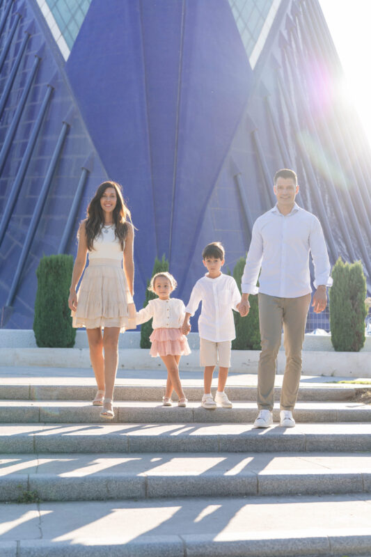 Familia disfrutando una sesión de fotos al atardecer en la Ciudad de las Artes y las Ciencias, Valencia, mostrando amor y cercanía.