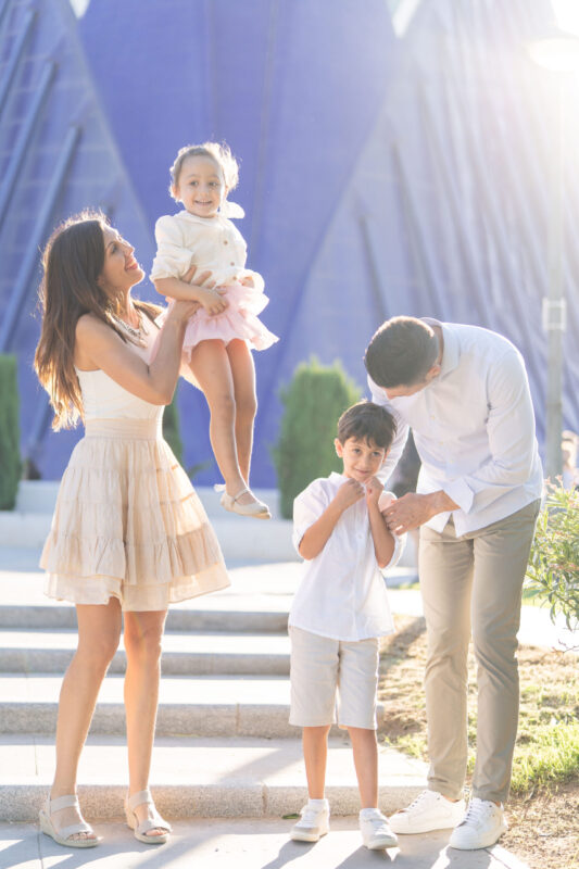 Sesión fotográfica familiar al aire libre en la Ciudad de las Artes y las Ciencias, Valencia, con luz cálida del atardecer.