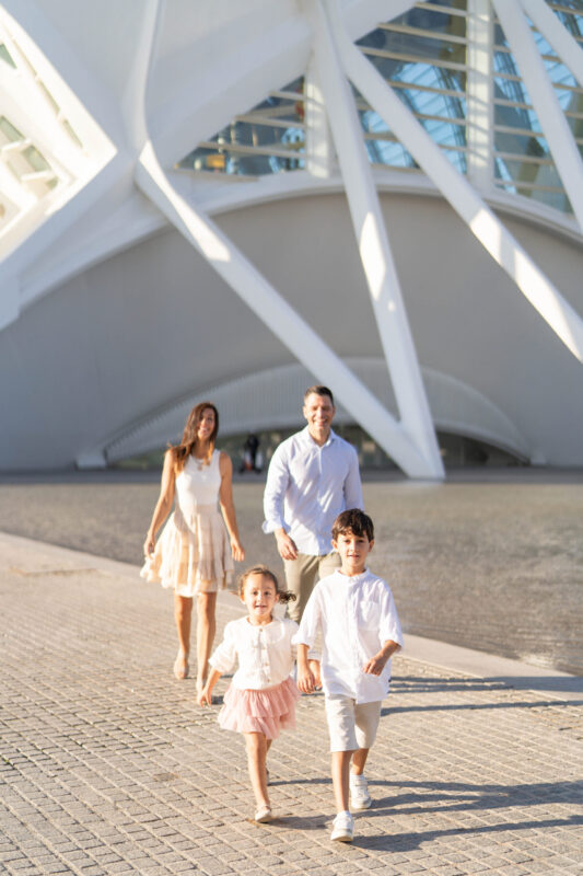 Fotografía profesional de familia al atardecer en la Ciudad de las Artes y las Ciencias, Valencia, mostrando alegría y cercanía.