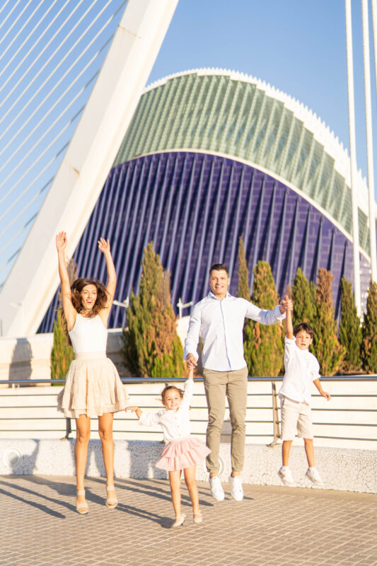 Fotografía de familia disfrutando momentos de cercanía y amor en la Ciudad de las Artes y las Ciencias, Valencia.